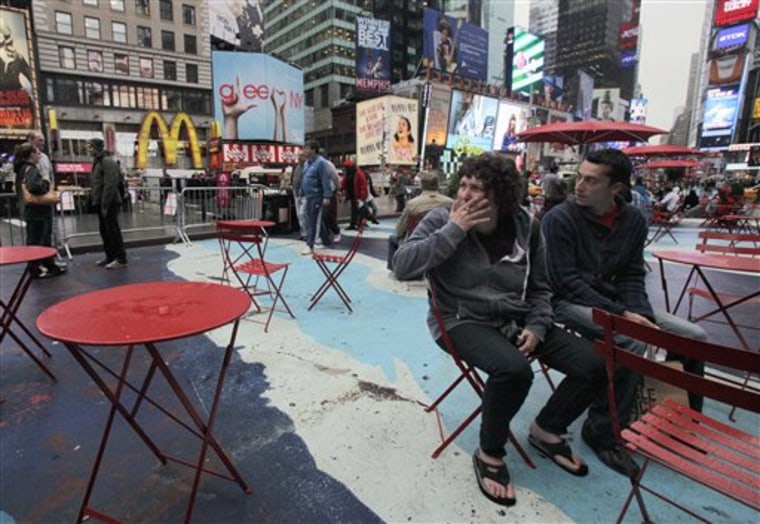 A woman smokes a cigarette in New York's Times Square. A new law bans smoking in New York City's 43 square miles of urban parks and other public places. The law will be enforced with a $50 fine per violation. 